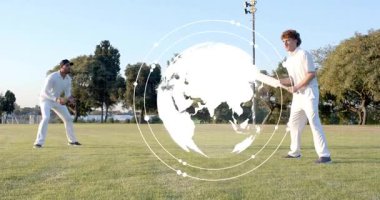 Vurucu kriket sahasında sallanıyor. Küre yükseliyor, saha dalışı yapıyor ve HUD top analizi yapıyor. Yarasa, açık hava, park, çimen, ikili, sporcular, ar