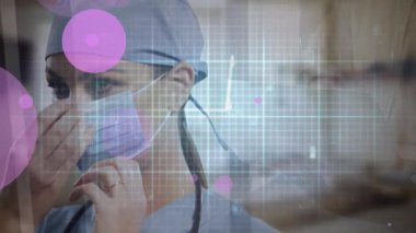 Kafkasyalı maske takan kadın doktorun üzerinde pembe noktaların hareketlenmesi. Coronavirus covid 19 salgını sırasında dijital olarak üretilen ilaç, sağlık ve sağlık hizmetleri.