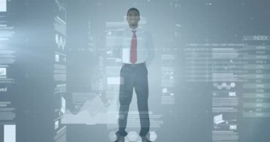 Gri arka plana karşı duran Afrikalı Amerikalı iş adamı hakkında istatistiksel veri işleme. iş verileri ve analitik teknoloji kavramı