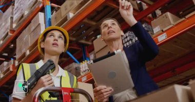 İşletme ölçümleri gösterilirken yönetici rafı gösterip stokları tarıyor. Tedarik zinciri, depo, lojistik, teknoloji, veri görselleştirme, sürdürülebilirlik, sanayi