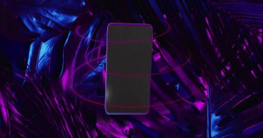 Stüdyoda parlak tropikal yaprakların üzerinde süzülen akıllı telefon, daireler çizen neon halkalar. Telefon, canavar, yeşillik, parıltı, mavimsi, fütürist, kaprisli