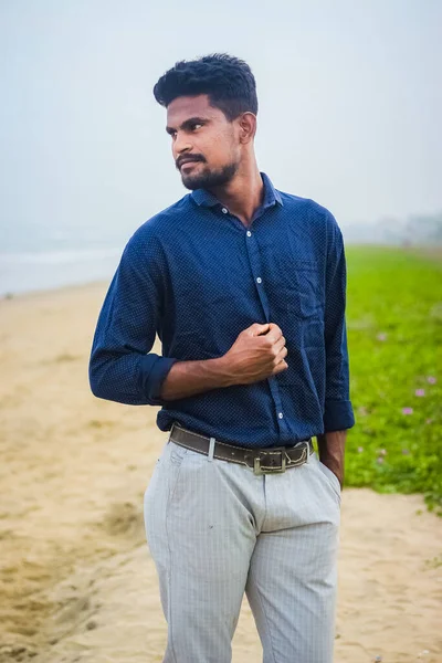 해수욕장에서 셔츠와 바지를 포즈를 취하는 상냥하고 자신감 해변에서 아시아인 남자의 — 스톡 사진