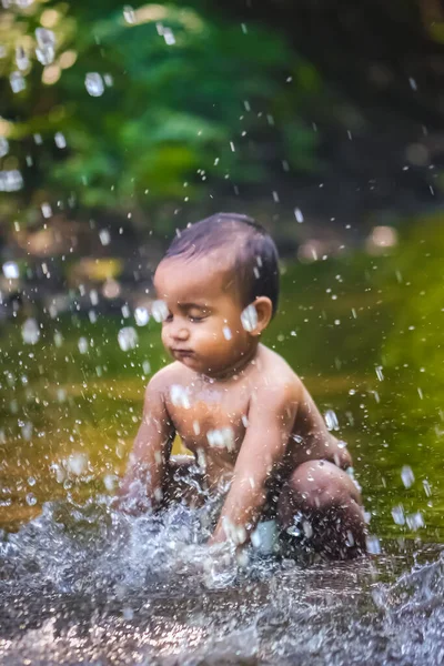 Küçük şirin bebek nehir suyunda oynuyor. Orman nehrinde eğlenen çocuk portresi. Küçük komik çocuk suda oynuyor. Baby Boy Resim Depolama.
