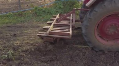 Chennai, Hindistan - 11 Şubat 2021: Kıdemli çiftçi tarım için topraklarını sürmek için eski bir traktör kullanıyor. Çiftçilerin Toprağı Sürme Gününde Mouldboard Plough ile Traktör Kullanımı.