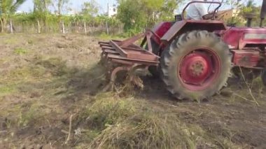 Chennai, Hindistan - 11 Şubat 2021: Kıdemli çiftçi tarım için topraklarını sürmek için eski bir traktör kullanıyor. Çiftçilerin Toprağı Sürme Gününde Mouldboard Plough ile Traktör Kullanımı.