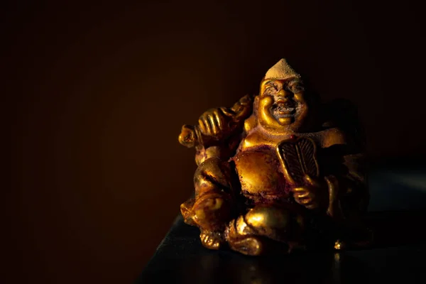 Laughing Buddha Statue on under the Tree. Statue of Laughing Buddha. Statue of kubera.