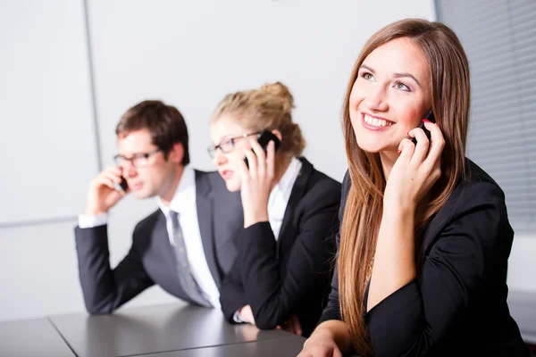 Uomini d'affari che fanno telefonate in riunione — Foto Stock