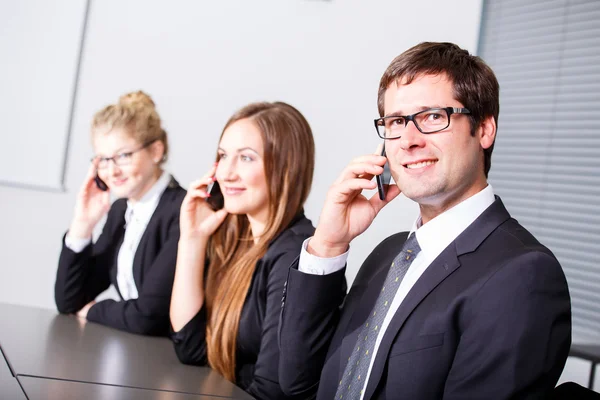 Uomini d'affari che fanno telefonate in riunione — Foto Stock