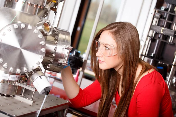 Ilmuwan wanita melihat ke ruang deposisi laser — Stok Foto