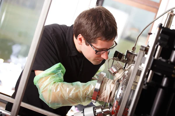 Scientist inserts hand laser deposition chamber — Stock Photo, Image