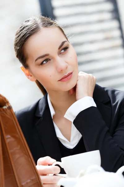 Femme d'affaires réfléchie prenant un café et regardant dans le fu Images De Stock Libres De Droits