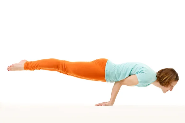 Estudio de una joven en forma haciendo un ejercicio de yoga de equilibrio de brazos . —  Fotos de Stock