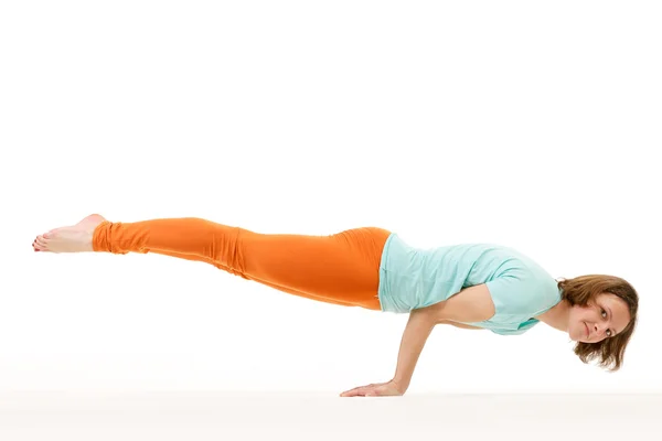 Studioaufnahme einer jungen, fitten Frau bei einer Armbalance-Yoga-Übung. — Stockfoto