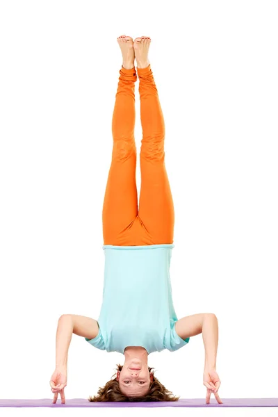 Mujer joven balanceándose en sus brazos mientras hace yoga . — Foto de Stock