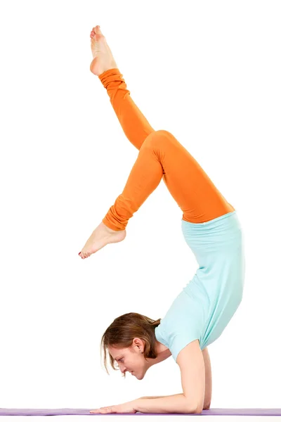 Estudio de una joven en forma haciendo un ejercicio de yoga de equilibrio de brazos . —  Fotos de Stock