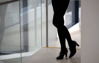 Güzel bir kadının bacakları, siyah pantolonu, siyah ayakkabıları, ofisi.