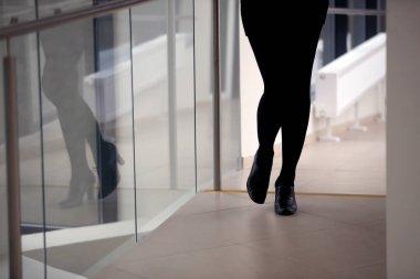 Güzel bir kadının bacakları, siyah pantolonu, siyah ayakkabıları, ofisi.