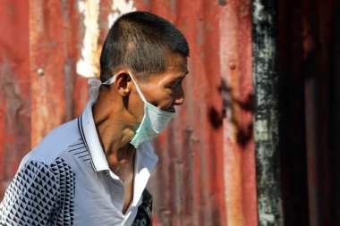 Hava kirliliğine karşı ağız maskesi takan bir Asyalı. Malezya