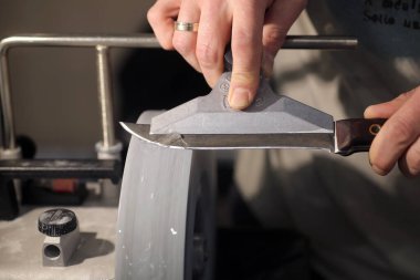 Bıçak bileyicisi ve bıçaklı bir el.