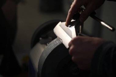 Bıçak bileyicisi ve bıçaklı bir el.