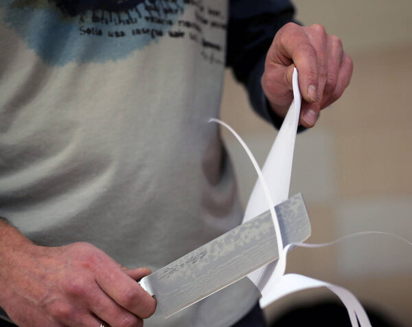 Knife sharpener and hand with blade