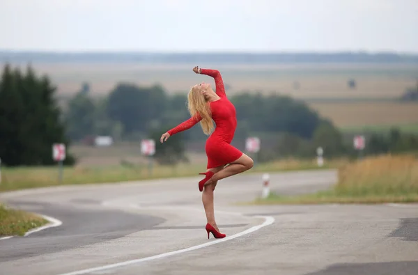 Σέξι Νεαρή Γυναίκα Ένα Κόκκινο Φόρεμα Μια Στροφή Γόνατος — Φωτογραφία Αρχείου