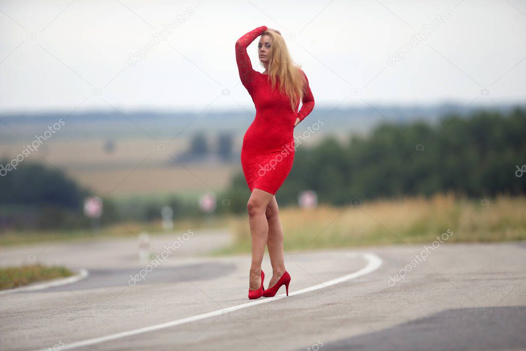 Sexy young woman with a red dress in a knee bend