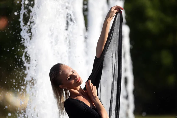 リトアニアのカウナス市の噴水に若いとても美しい女性がポーズをとっています — ストック写真