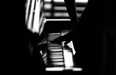 Genç ve çekici bir kız piyano çalıyor, çıplak bir figür. 