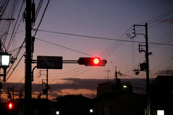 Traffic light with red light against the evening sky