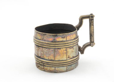 Beyaz arka planda eski bakır bardak.