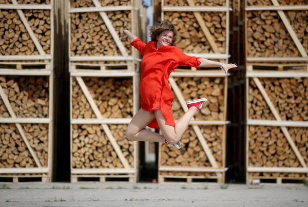 Saltando Mulher Bonita Vestido Vermelho Backgroun Lenha — Fotografia de Stock