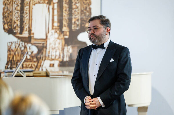 Оперный певец Рафайлас Карпис выступил на концерте классической музыки в Мультикультурном центре Кедайняй 9 февраля 2025 года. Исполнитель одет в официальный костюм и поет выразительно в интимной культурной обстановке