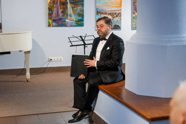 Оперный певец Рафайлас Карпис выступил на концерте классической музыки в Мультикультурном центре Кедайняй 9 февраля 2025 года. Исполнитель одет в официальный костюм и поет выразительно в интимной культурной обстановке