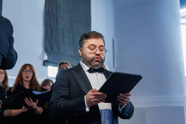 Оперный певец Рафайлас Карпис выступил на концерте классической музыки в Мультикультурном центре Кедайняй 9 февраля 2025 года. Исполнитель одет в официальный костюм и поет выразительно в интимной культурной обстановке