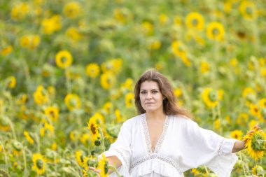 Ayçiçekleri Tarlasında Beyaz Giyen Kadın: Sarı Çiçekler Arasındaki Huzur Anı