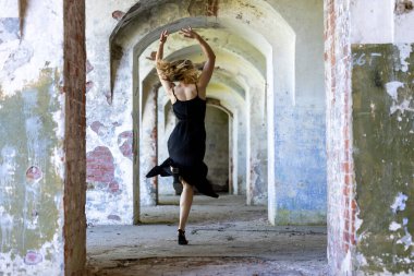 Terk edilmiş bir koridorda hareketli hareketler yapan akıcı siyah elbiseli, çağdaş dansçı. Özgürlük kavramı, zarafet, kadınlık, hareket ve kabataslak mimari arasındaki zıtlık