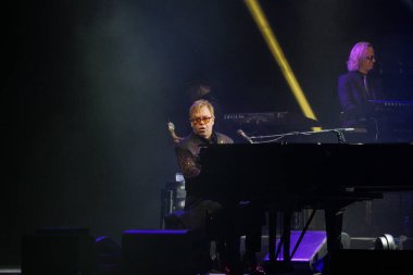 İngiliz müzisyen Elton John 19 Aralık 2013 'te Litvanya' nın Kaunas kentinde verdiği konserde piyano başında canlı performans sergiliyor. Sahne ışıklandırması, müzisyenler ve konser atmosferi canlı gösteri sırasında kaydedildi.