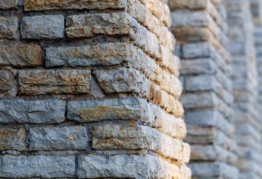 Dikey kolonların tekrarladığı tarihi taş duvar ritim ve derinlik yaratıyor. Doğal duvar dokusu, perspektif çizgileri ve nötr tonlar. İdeal mimari arkaplan, inşaat kavramı veya minimalist tasarım kullanımı.