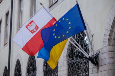 Poland Polish,Ukrainian and European Union flags displayed together on the facade of a historic building. Visual symbol of European solidarity, unity and support for Ukraine in the current geopolitical context