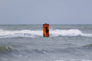 Paslı metal direk bulutlu gökyüzünün altında dalgalar halinde duruyor. Güçlü ruh hali, hareket ve kopyalama alanı olan minimalist deniz sahnesi. Dayanıklılık, izolasyon, sanayi ve doğa kavramı