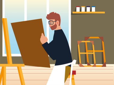 Çizgi film ressamı elinde tuval stüdyoda oturuyor.