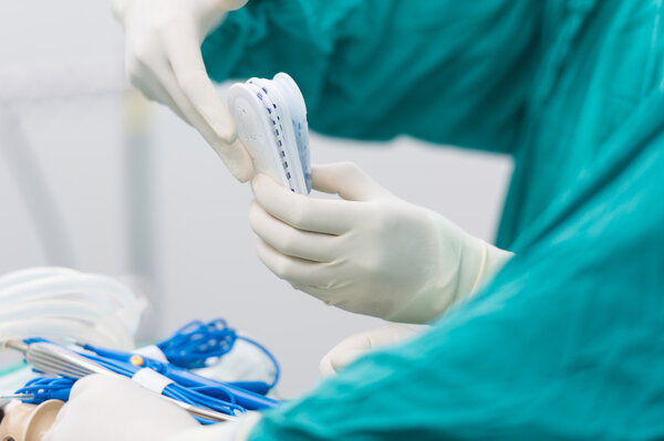 Scrub nurse preparing tools for operation