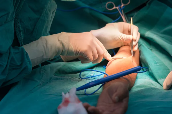 Young female surgeon doing operation — Stock Photo, Image