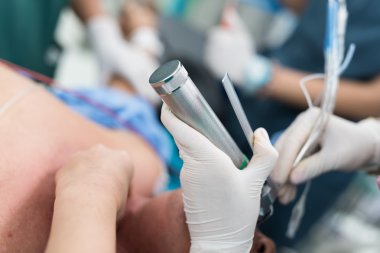 doctor apply laryngoscope for endotracheal intubation clipart