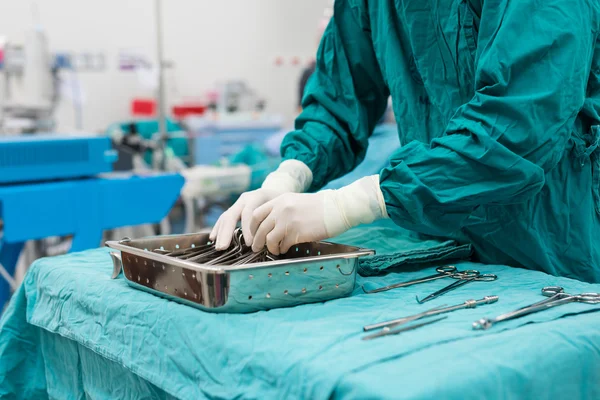 Enfermeira de esfoliação preparando instrumentos médicos para a operação — Fotografia de Stock