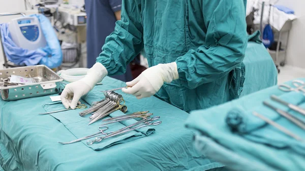 Enfermeira de esfoliação preparando instrumentos médicos para a operação — Fotografia de Stock