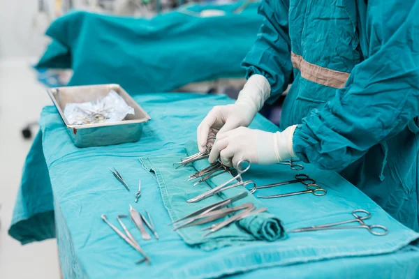 Enfermera de matorral preparando instrumentos médicos para la operación — Foto de Stock