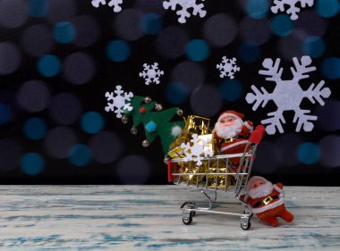 Noel Baba 'nın Noel hediyeleri ve el arabasının arka planında bir ağaç taşıması, Noel arkaplanı, soyut bir arka plan.