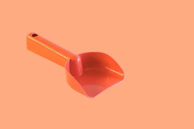 Çocuk kepçesi, turuncu renkli, yumuşak turuncu arka planda, ben...